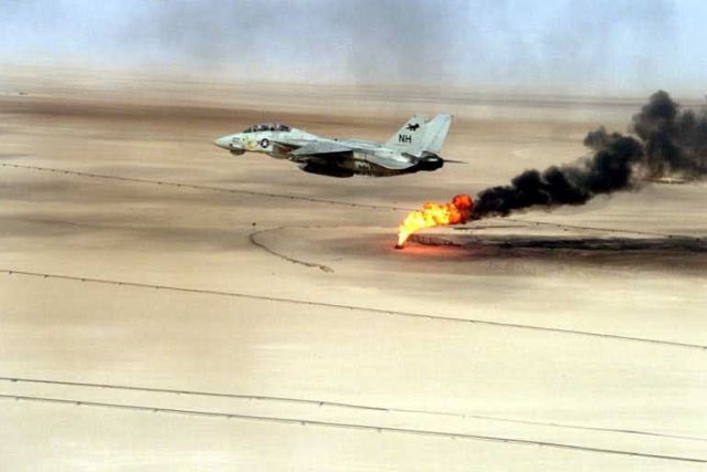 Navy F-14 - A Navy F-14 Tomcat flying over a burning oil field in Kuwait Picture