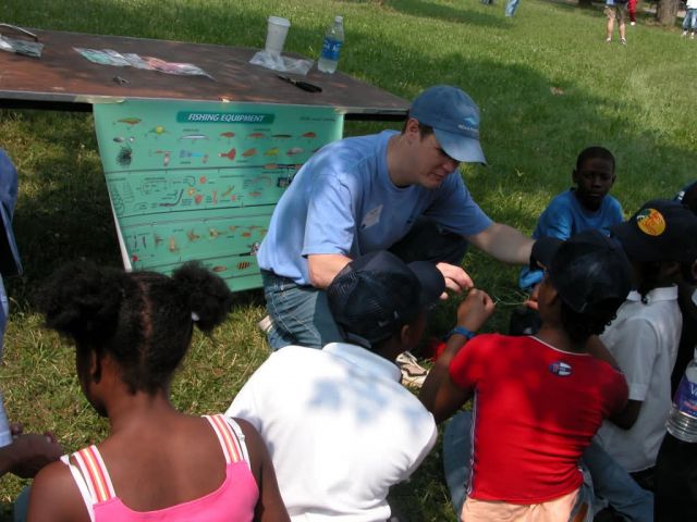 Volunteer show children about fishing equipment Picture