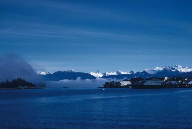 The Devil's Thumb of the Alaska coastal ranges rises above the morning fog of the Inside Passage at Petersburg, Alaska. Picture