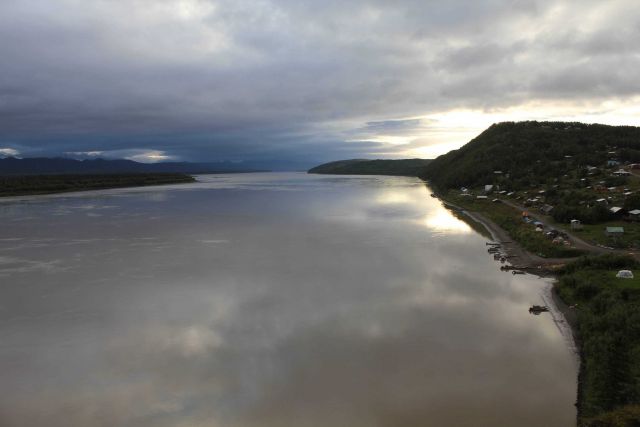 A glassy Yukon River reflects early morning clouds at Ruby Picture
