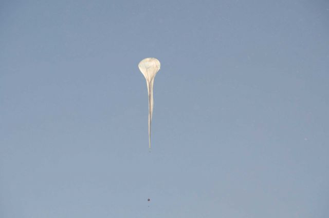 An ozonesonde balloon rises into a clear South Pole sky. Picture