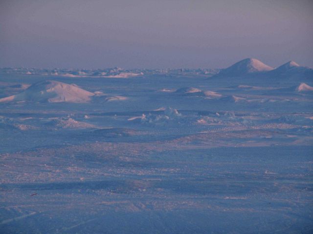 A low-angle sun illuminates hummocks on the Arctic ice. Picture