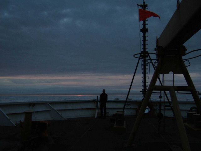 A lone member of the HEALY science party contemplates an Arctic sky and seascape. Picture