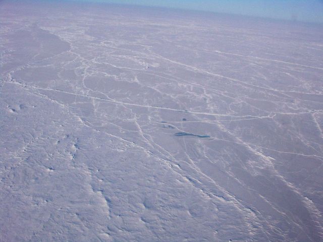 Pressure ridges, hummocks, and the frozen remains of a melt pond in the middle of the image. Picture