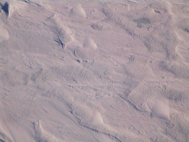 Hummocky ice, what appear to be refrozen icicles but probably caused by wind effects, rough surface caused by wind ablation, and other structures in m Picture