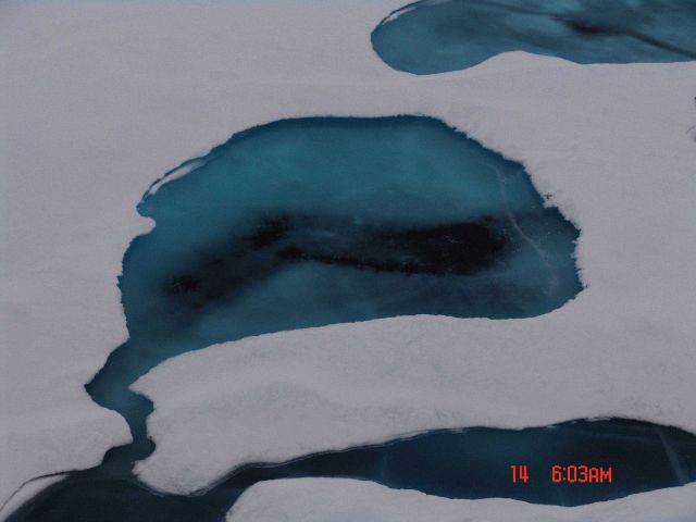 A melt pool that although has frozen over , has melted through to the ocean below. Picture
