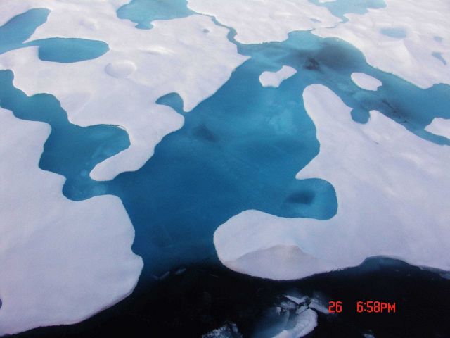 Melt pools breaking through with the dark area at bottom being Arctic seawater. Picture