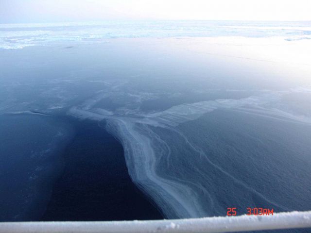 Frazil ice on lower left of image, nilas to right and ice floes extending to horizon. Picture