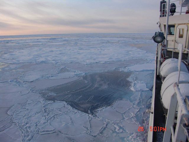 Ice floes in distance, nilas ice in bottom center, and large pancakes frozen together in lowest center. Picture