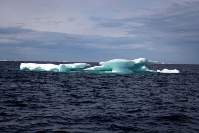 NOAA Ship FAIRWEATHER seen in the distance with a mushroom shaped melting floe in the foreground. Picture
