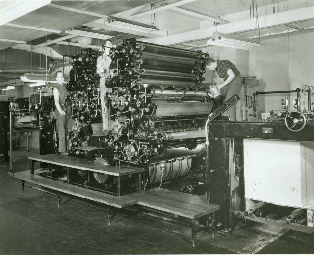 Coast and Geodetic Survey pressmen in action on a Harris press. Picture