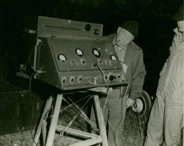 Pappy Shelton, chief of the first geodimeter party, using Model 2A geodimeter Picture
