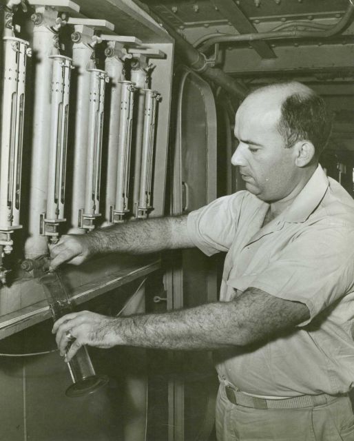 Chief Survey Technician removing seawater from Nansen bottle for analsyis. Picture