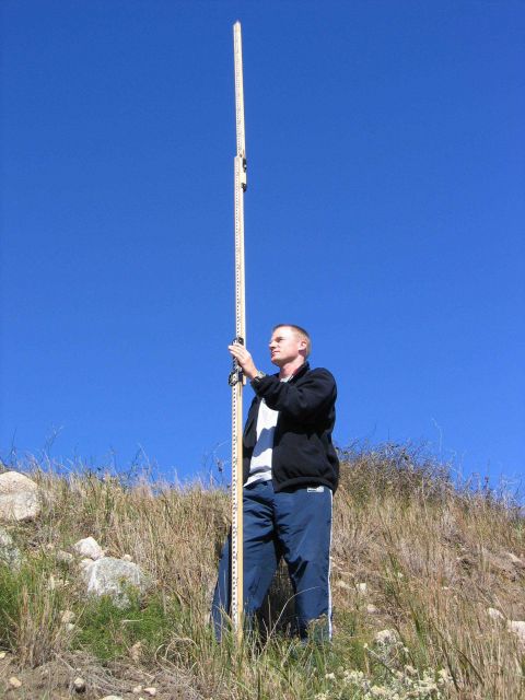 Rodman holding rod steady during leveling operations in support of Quicks Hole tide gauge removal. Picture