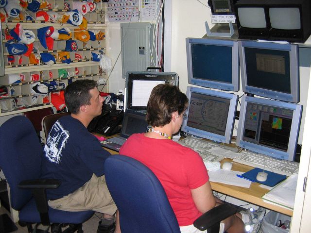 Monitoring survey data on array of computer screens. Picture