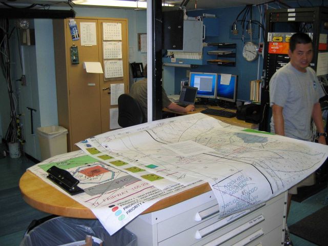 Monitoring survey data on array of computer screens. Picture