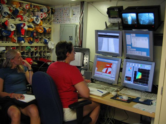 Monitoring survey data on array of computer screens. Picture