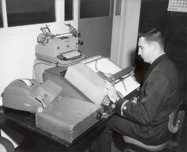 USC&GS ensign using marigram tide tabulating machine. Picture