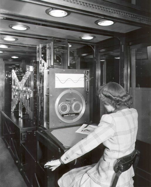Woman professional operating the USC&GS tide prediction machine during World War II. Picture