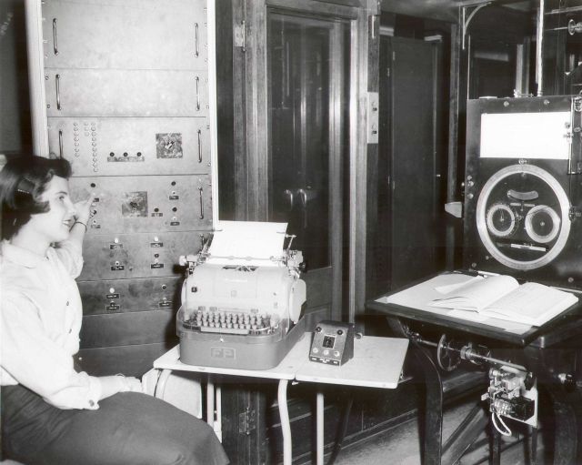 Coast Survey employee Susan Tully using new automated tabulating machine for recording tides predicted on Tide Prediction Machine No Picture
