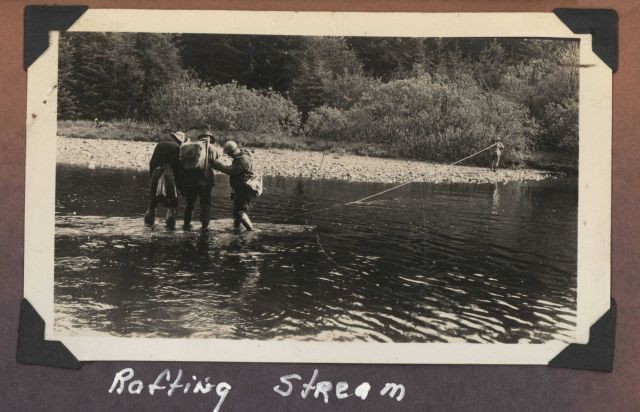 Work party crossing small stream on improvised raft - perhaps a little too much weight. Picture