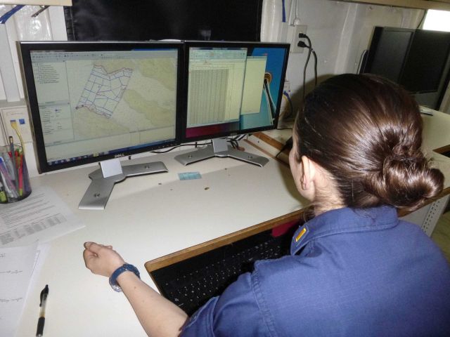 Ensign Micki Ream working on survey planning on NOAA Ship RAINIER. Picture