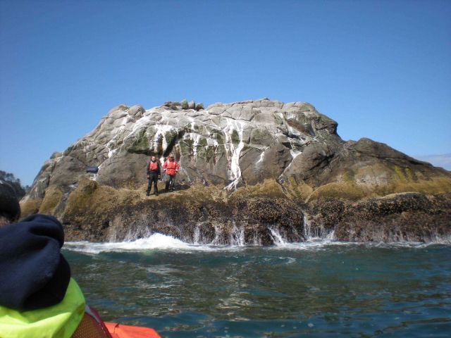 Waiting to unload additional equipment for horizontal control station at low tide on a steep sided rock Picture