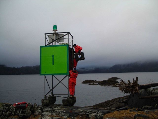 Establishing horizontal control station on Coast Guard daymarker. Picture