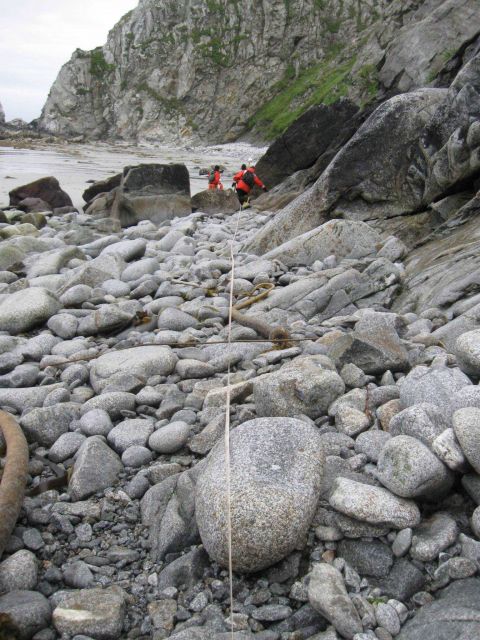 Measuring distance between tidal bench marks on a boulder beach. Picture