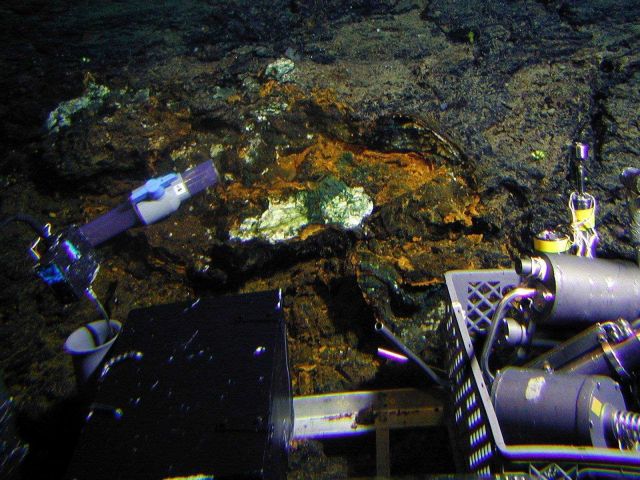 Sampling hydrothermal oxide/silica crusts and a sponge at Clark Volcano ( 994 meters depth). Picture