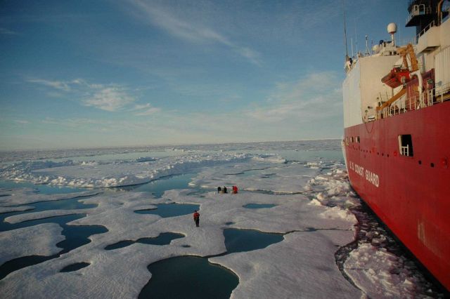 Scientist conducting operations on the ice next to the Coast Guard ice breaker HEALY. Picture