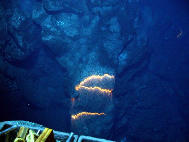 Bands of glowing magma, about 2,200 degrees Fahrenheit, are exposed as a pillow lava tube extrudes down slope Picture