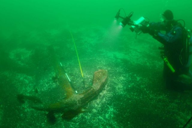 Dave McMahan, Alaska State Archaeologist, shooting video of large Kad'yak anchor. Picture