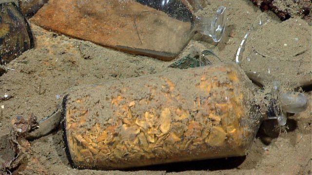 Clear glass bottle with original contents still intact; possibly ginger Picture