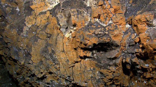 Circular volcanic feature heavily altered by hydrothermal activity. Picture