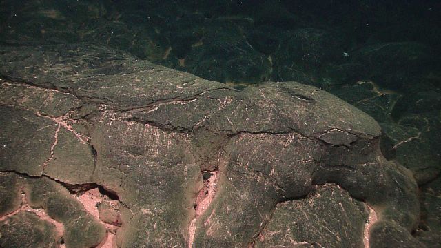 Smooth baked appearance with pink alteration along cracks. Picture