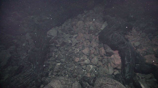 Smooth fairly new black shiny lava overlying angular lava boulder field. Picture