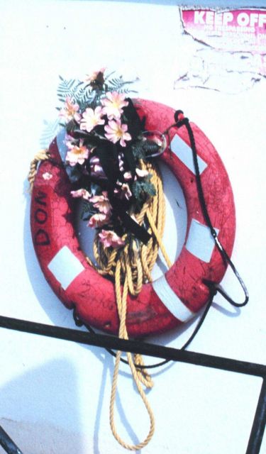 A decoration? A memorial? Perhaps a celebration? Flowers grace a shrimp boat in Conn Brown Harbor. Picture