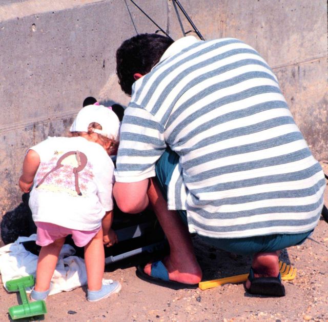Daddy's helper assists in preparing tackle while fishing at Manasquan Inlet. Picture