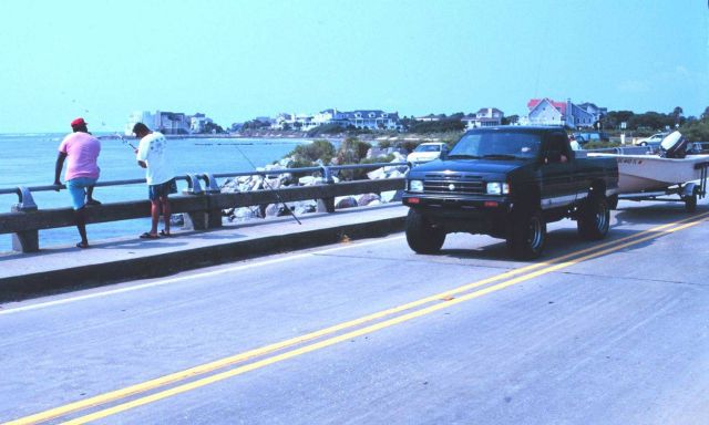 Fishermen use bridge while passing truck tows boat in search of better fishing Picture