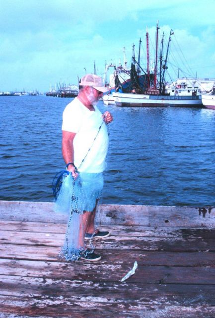 Marty Millard, a charter boat captain, casts for bait mullet in Conn Harbor Picture
