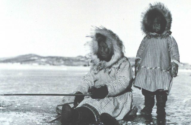 Eskimo woman and child ice fishing in the Bering Sea Picture