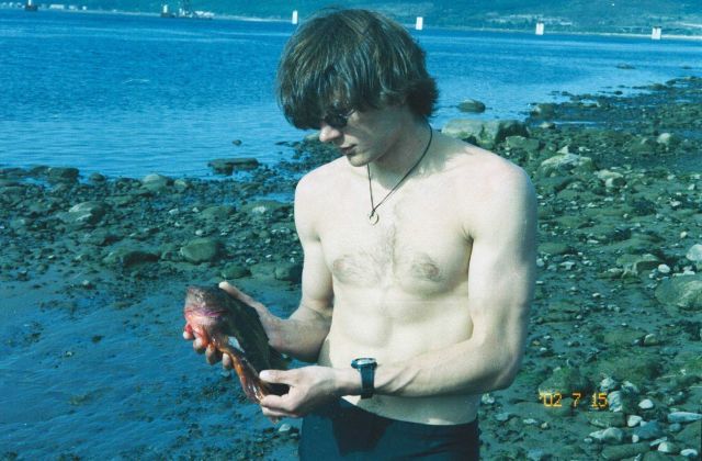 Yury Zuyev with rockfish (Cyclopterus lumptus) along shore of Barents Sea at Kola Bay at Drovianoe, Lat Picture