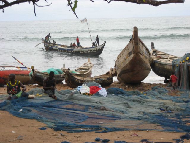 Ghanaian fishers mending nets Picture