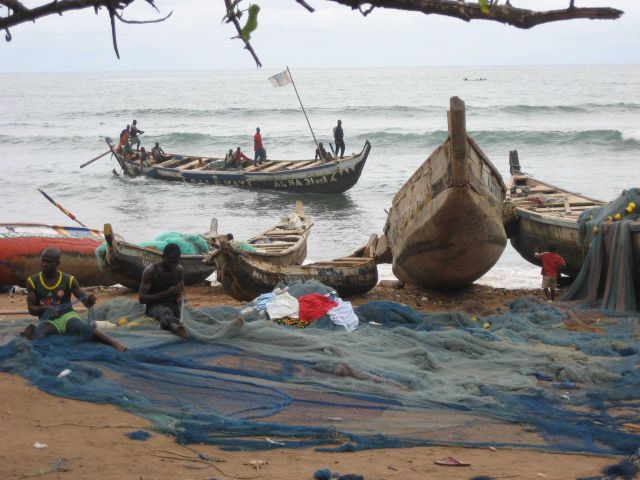 Ghanaian fishers mending nets Picture