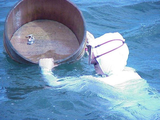 Ama woman demonstrates how pearl oysters are carried back to the boat. Picture