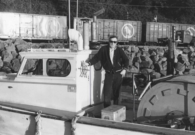 Salmon gill net boat with the captain at the wheel with the Great Northern Railway in the background. Picture
