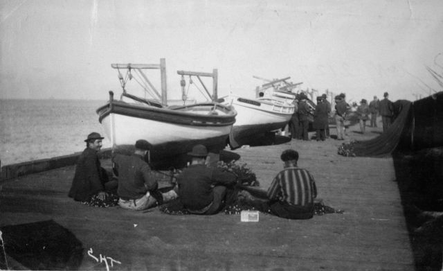 Mending nets on pier. Picture