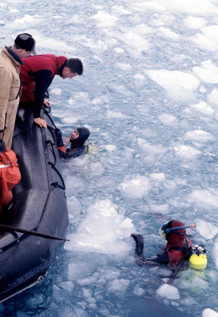 A pair of SCUBA divers look to climb out of the icy water and back aboard the Zodiac Picture