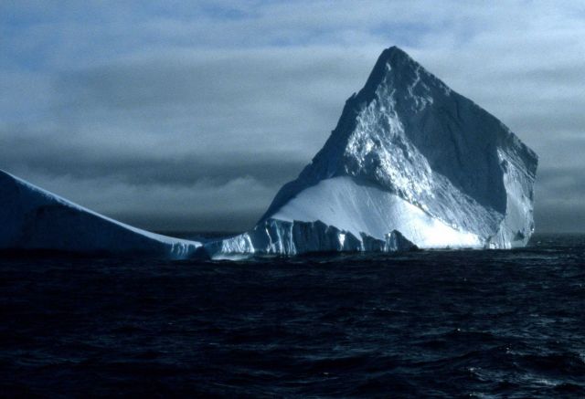 A tabular iceberg, being reshaped by the wind and ocean. Picture